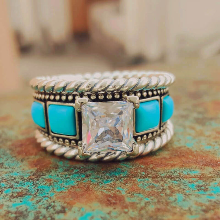 Silver twist band ring showcasing square turquoise stone and diamond centerpiece