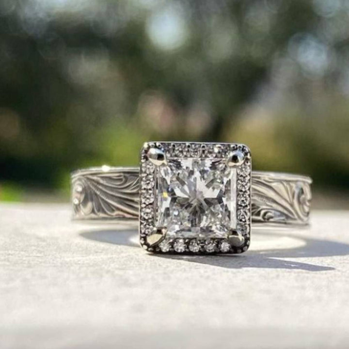 Flower engraved square diamond ring featuring a sparkling zircon gem against a natural backdrop.