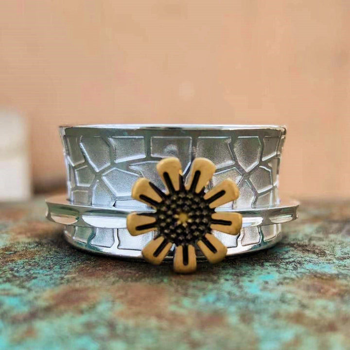 Textured steel band ring with sunflower design and gold accent