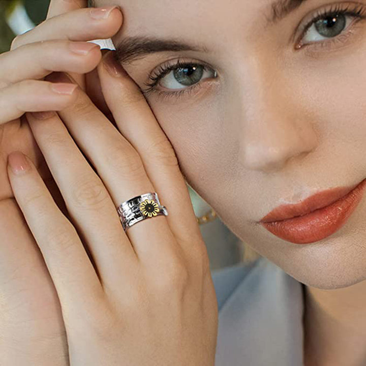 Model wearing steel sunflower band ring with gold accent and textured design