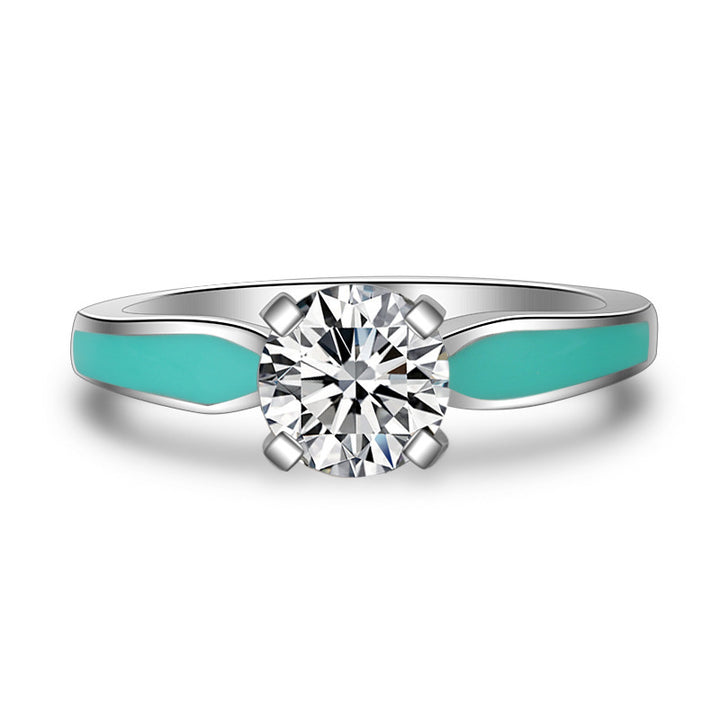 Sterling silver engagement ring with round moissanite and turquoise accents.