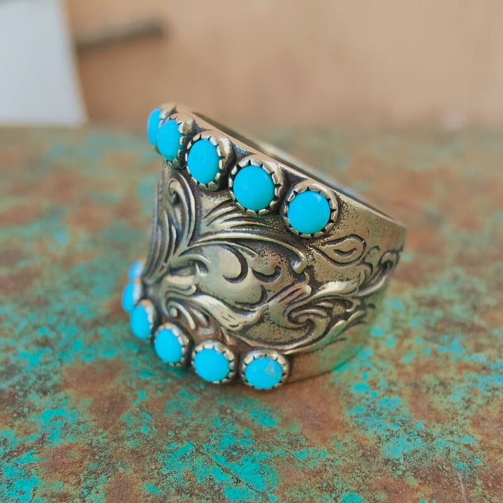Decorative silver ring featuring multiple turquoise gemstones in a floral motif