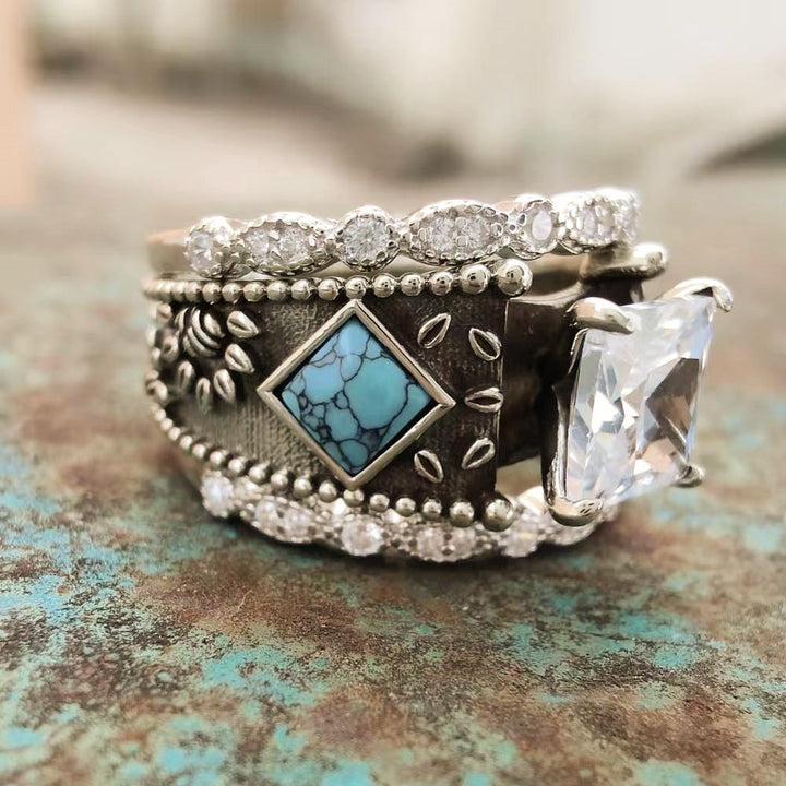 Sterling silver ring with turquoise and diamond accents on a textured background.