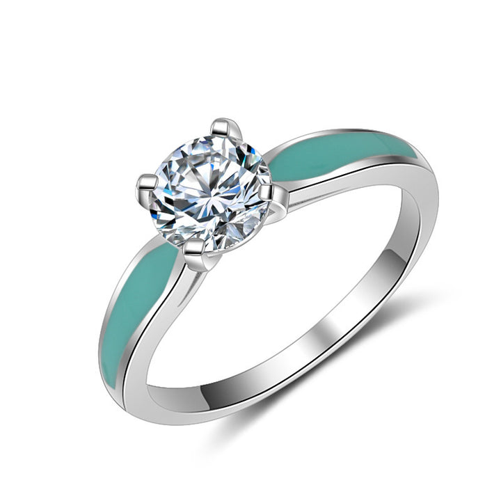 Sterling silver engagement ring with round cut moissanite and turquoise inlays.