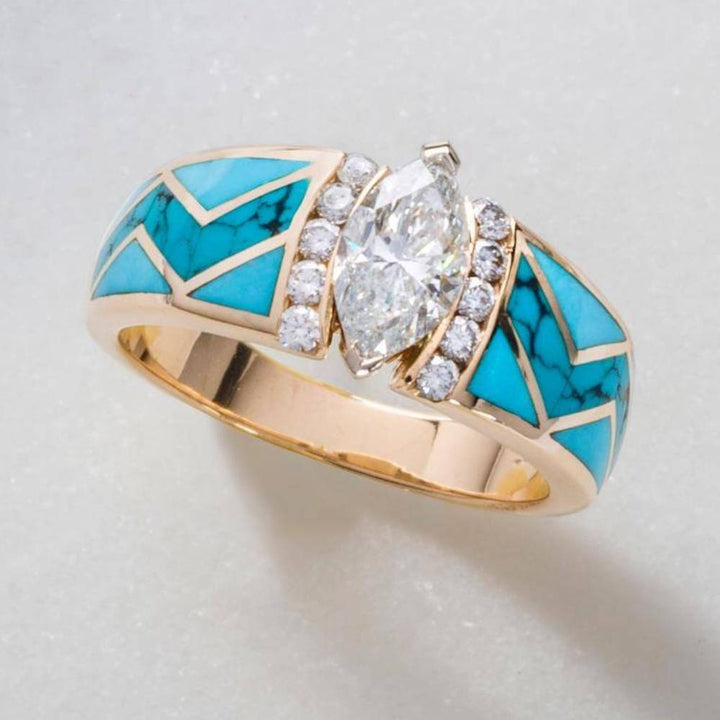 Gold ring with marquise diamond and turquoise inlay, accented with small diamonds.