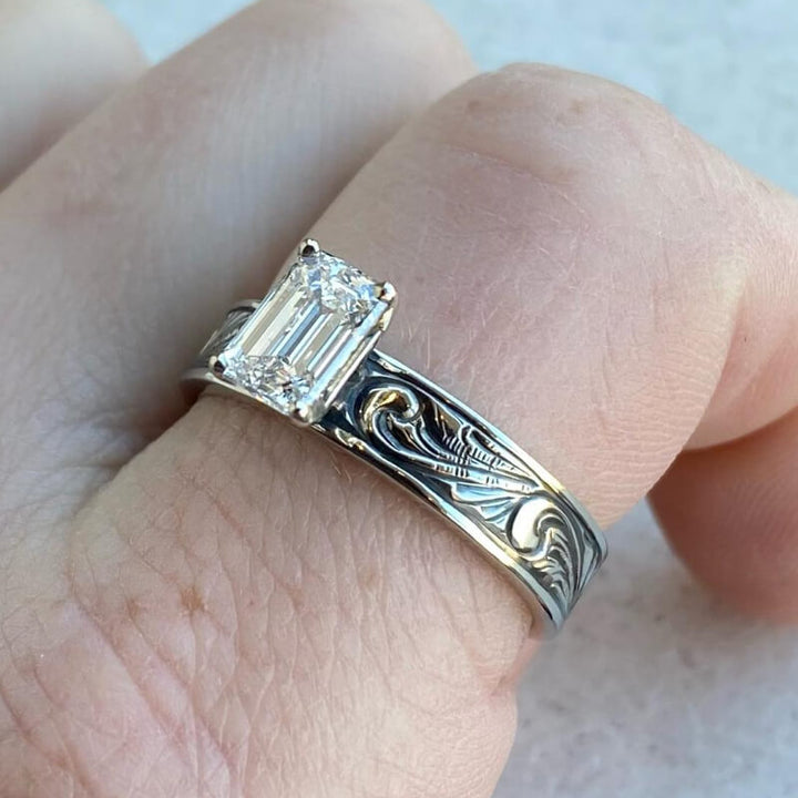 Western engagement ring with emerald-cut zircon on intricately engraved black band
